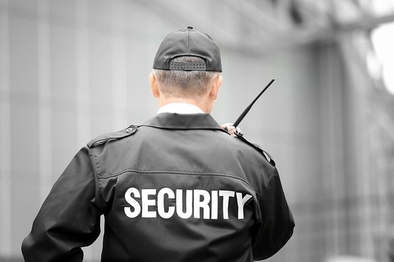 male security guard using portable-radio outdoors